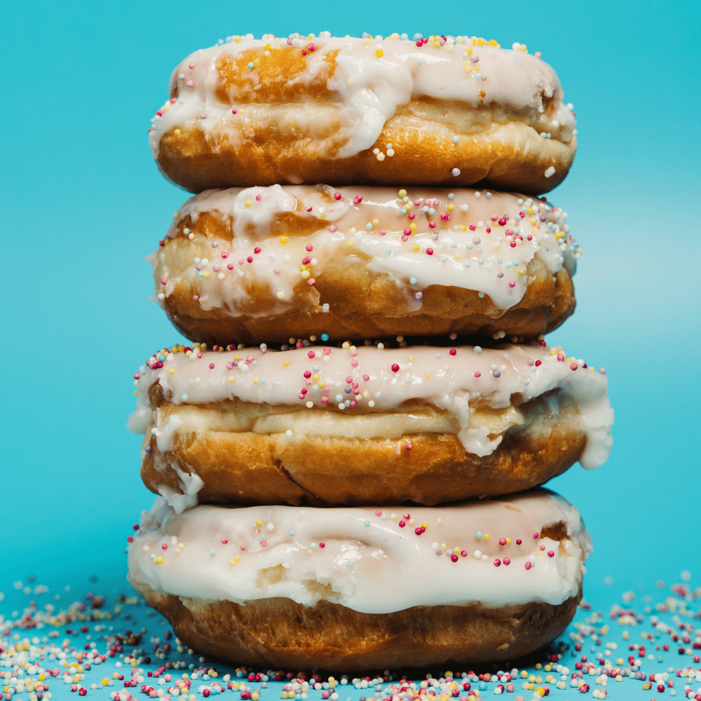A stack of glazed sprinkled doughnuts